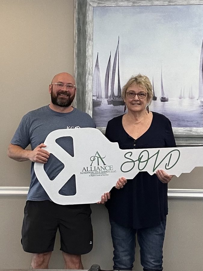 Kansas City homeowner with KC Home Offers holding a SOLD key at closing